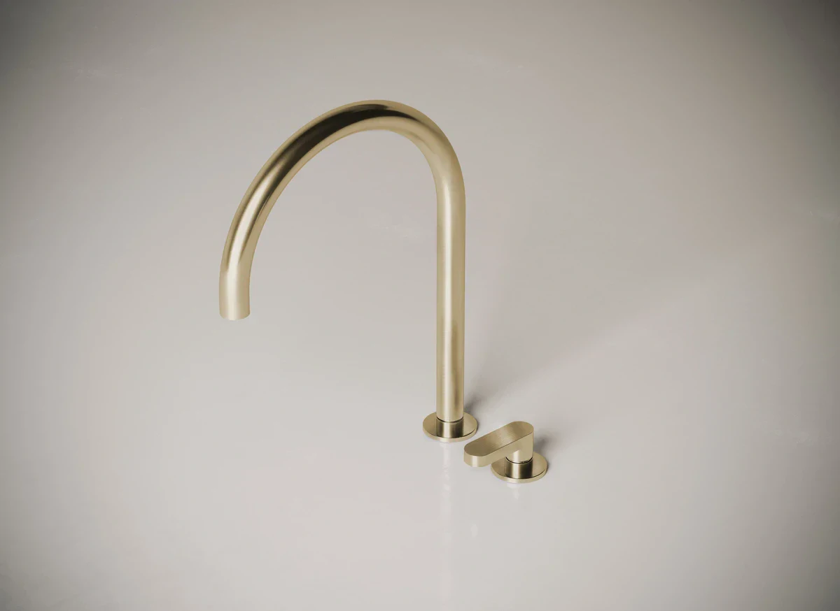 Brass kitchen faucet with single handle on a light background.